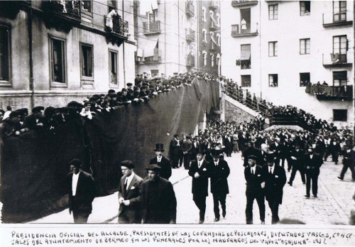 Osasuna eta Izaro baporuntzien arteko txokean ito ziren arrantzaleen aldeko hiletak: Monasterio aurreneko filaren erdian dago, korbata eta txapelarekin. Eskuma-ezkerrean, kofradietako presidenteak. Atzean, Gorteetako diputatuak.